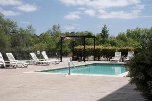 uma piscina com espreguiçadeiras e um cesto de basquetebol em Riverleaf Inn Mission Valley em San Diego