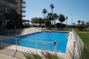 een groot zwembad met een hek eromheen bij Apart EAM Maite 3 in Benalmádena