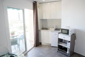 een kleine keuken met een spoelbak en een magnetron bij Apart EAM Maite 3 in Benalmádena