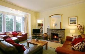 a living room with two couches and a fireplace at Netherwood House in Newtonmore