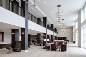 a lobby of a hotel with chairs and tables at Hotel Madison & Shenandoah Conference Ctr. in Harrisonburg