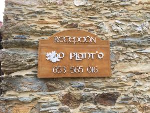 a sign on the side of a stone wall at O Plantio in Porto de Espasante