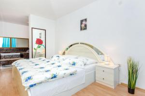 ein Schlafzimmer mit einem weißen Bett mit blauen und weißen Kissen in der Unterkunft Apartments and Room Napoli in Bol