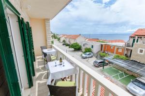 a balcony with a table and chairs and a view of the ocean at Apartments and Room Napoli in Bol