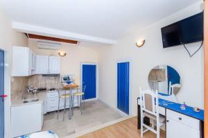 a kitchen with white cabinets and a blue counter top at Apartments and Room Napoli in Bol