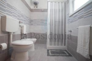 bagno bianco con servizi igienici e doccia di LaCassiopea a Donnalucata