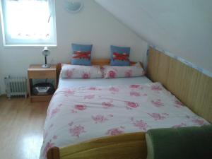 ein Schlafzimmer mit einem Bett mit rosa Blumen drauf in der Unterkunft Chata Bešeňová in Bešeňová
