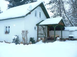 una casa bianca con la neve sul tetto di Chata Bešeňová a Bešeňová