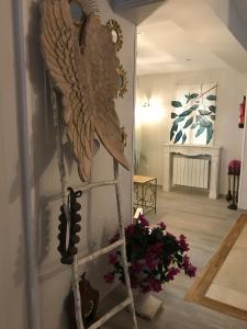 una scala con un'aquila sul muro in una stanza con dei fiori di Hotel Boutique Albussanluis a Muriedas
