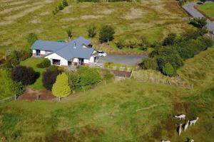 an aerial view of a house on a green field at Alpaca Farmstay in Dunedin
