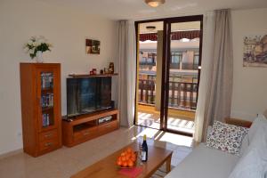a living room with a couch and a television at Olivia Sunset Playa in Puerto de Santiago