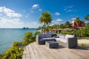 a patio with two couches and the water at Casa Coco by Coco B Isla in Isla Mujeres