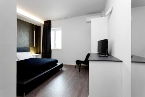ガリポリにあるMinimal Roomsのベッドルーム1室(ベッド1台、デスク、テレビ付)