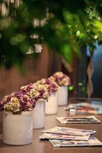 a row of vases filled with flowers on a table at Voyage Hotel in Karagandy