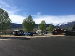 a campsite with a truck parked in front of a building at Green Creek Inn and RV Park in Wapiti