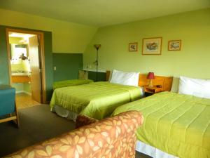 Habitación de hotel con 2 camas y sofá en Country Motor Inn, en Livingston