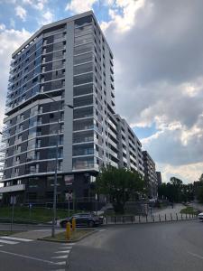 un grand bâtiment avec une voiture garée devant lui dans l'établissement Klopot 4 Apartment, à Varsovie