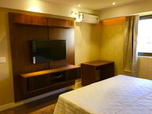 1 dormitorio con 1 cama y TV de pantalla plana en Fresh Hotel, en São Paulo