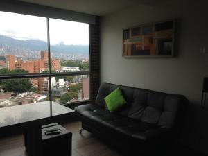 ein Wohnzimmer mit einem Sofa und einem großen Fenster in der Unterkunft All Inclusive Suites in Medellín