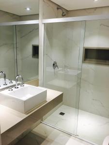 uma casa de banho branca com um lavatório e um chuveiro em Fresh Hotel em São Paulo