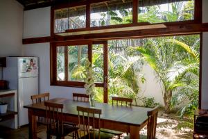 cocina con mesa, sillas y ventana en Tropical House - Villa com piscina perto do mar, en Jericoacoara