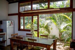 Una cocina con mesa y sillas y una ventana. en Tropical House - Villa com piscina perto do mar, en Jericoacoara