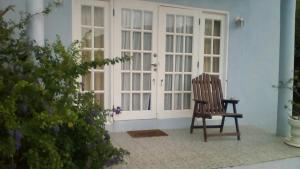 una sedia in legno seduta di fronte a una porta di Seaclusion a Gros Islet