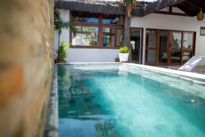 a swimming pool in front of a house at Tropical House - Villa com piscina perto do mar in Jericoacoara