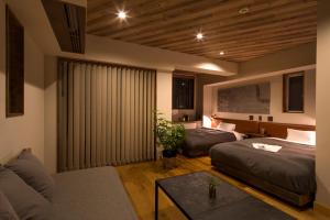 uma sala de estar com duas camas e um sofá em Hotel Vintage Tokyo em Tóquio