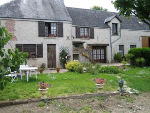 a white house with a table and chairs in the yard at Ferme Peschard in Séris