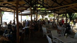 a group of people sitting at tables in a restaurant at Ana Warung & Bungalows in Gili Meno