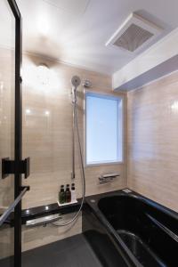 a bathroom with a bath tub and a window at Hotel Vintage Tokyo in Tokyo