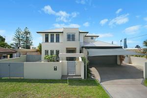 a white house with a gate and a fence at Escape to the Coast in Gold Coast