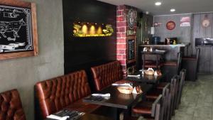 a restaurant with tables and leather seats in a room at All Inclusive Suites in Medellín