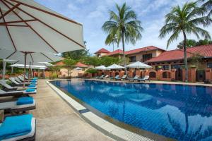 珍南海灘的住宿－蘭卡威卡薩德爾瑪爾度假酒店，一个带躺椅和遮阳伞的大型游泳池