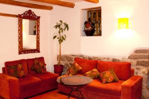 ein Wohnzimmer mit zwei roten Sofas und einem Tisch in der Unterkunft Amaru Colonial in Cusco