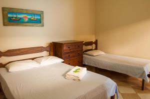 a bedroom with two beds and a dresser in it at Refron du Mar Pousada Paraty in Paraty