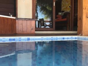 - une piscine avec du carrelage bleu dans une maison dans l'établissement Erakor Island Resort & Spa, à Port Vila