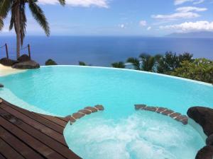 a swimming pool with the ocean in the background at Villa Paradise Tahiti Mata Miti in Punaauia
