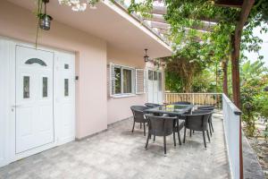 a patio with a table and chairs and a white door at Nissi Maria Villa in Ayia Napa