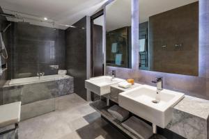 a bathroom with two sinks and a mirror and a tub at The Beetson Hotel in Brisbane