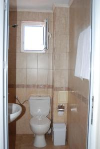 łazienka z toaletą, umywalką i oknem w obiekcie Rodos House w mieście Pomorie