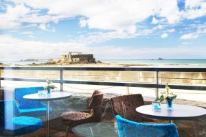 Elle offre une vue sur la terrasse dotée de tables et de chaises ainsi que sur l'océan. dans l'établissement Oceania Saint Malo, à Saint-Malo