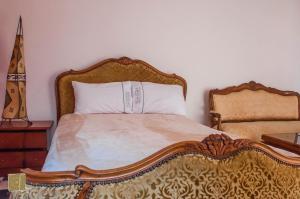 a bed with a wooden headboard and pillows at Riad Jbara in Rabat