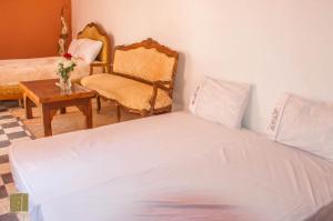 a bed sitting in a bedroom next to a lamp at Riad Jbara in Rabat