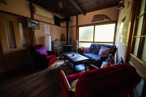 a living room with couches and a table in a room at YOKI Guest House in Miyoshi