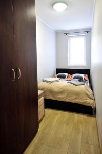 ミエンジズドロイェにあるApartament Gryfa Pomorskiego Międzyzdrojeのベッドルーム1室(ベッド1台付)、木製キャビネットが備わります。