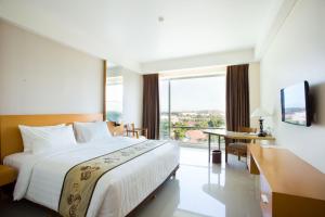 a hotel room with a bed and a large window at Golden Palace Hotel Lombok in Mataram