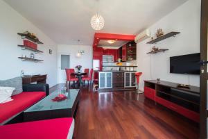 a living room with a red couch and a table at De Luxe Apartment Mediteran 3**** in Dubrovnik
