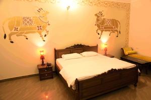 een slaapkamer met een bed met twee koeien aan de muur bij Vijaigarh Kothi - Heritage boutique in Varanasi